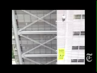 Alain Robert climbs the NY Times building to protest about global warming for the Solution is Simple campaign